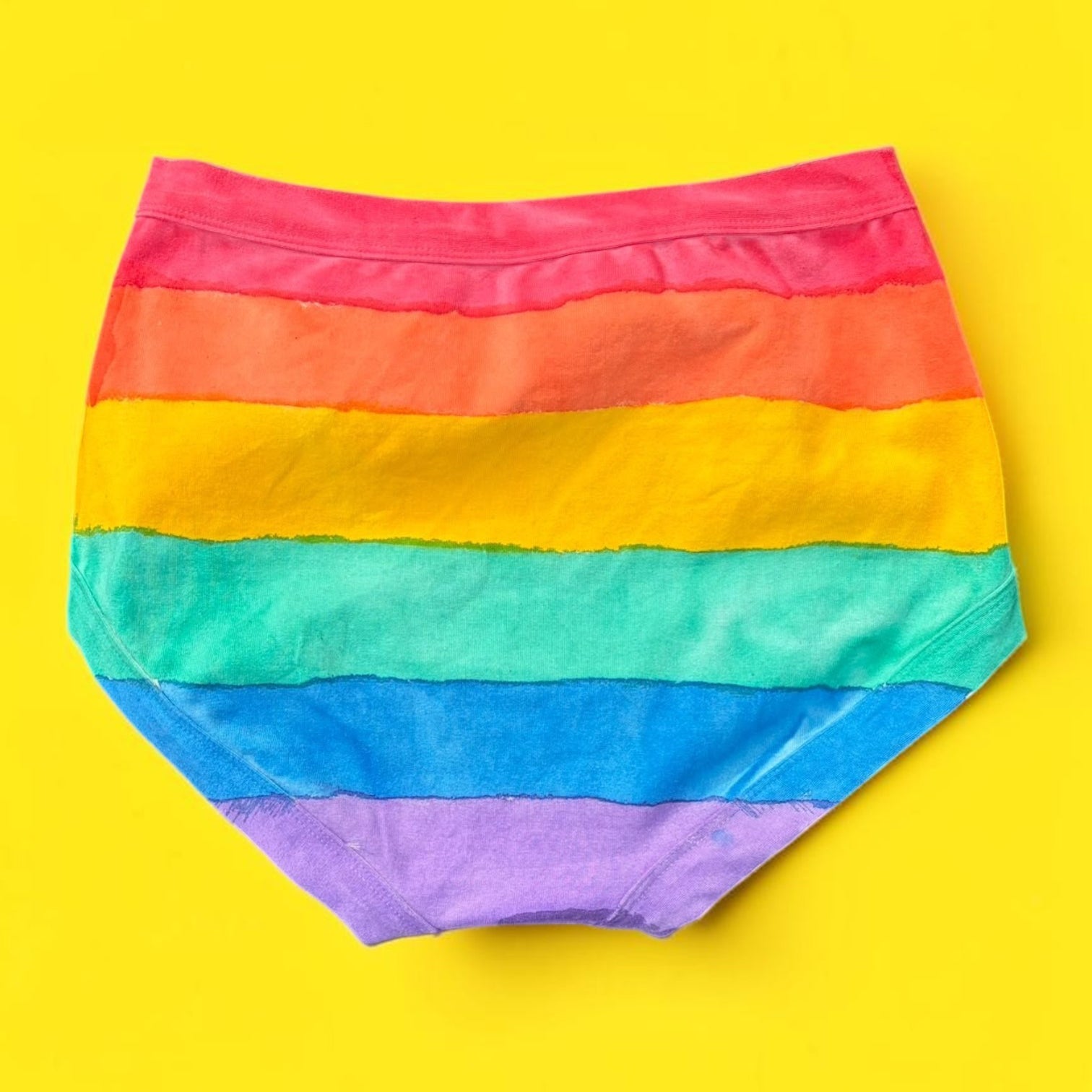 The back of the Rainbow striped originals laid flat on a bright yellow background.