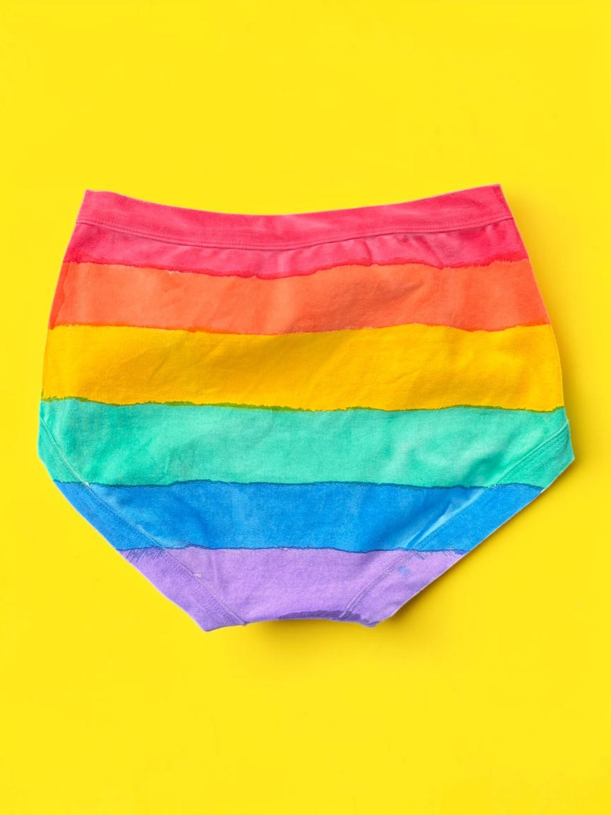 The back of the Rainbow striped originals laid flat on a bright yellow background.