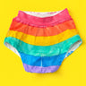 Rainbow-striped briefs with front pouch laid flat on a bright yellow background.